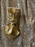 Gold Satin Luxe Tie with knotted bow detail on silver sequin backdrop