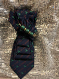 Navy holiday reindeer roll tie with green pearl bead and gold ring embellishments on sequin background